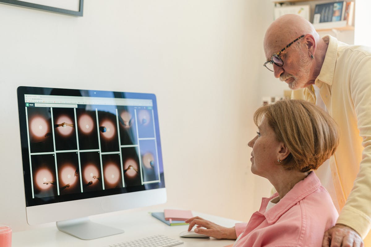 A senior couple sitting together at a table, learning about technology with curiosity and ease