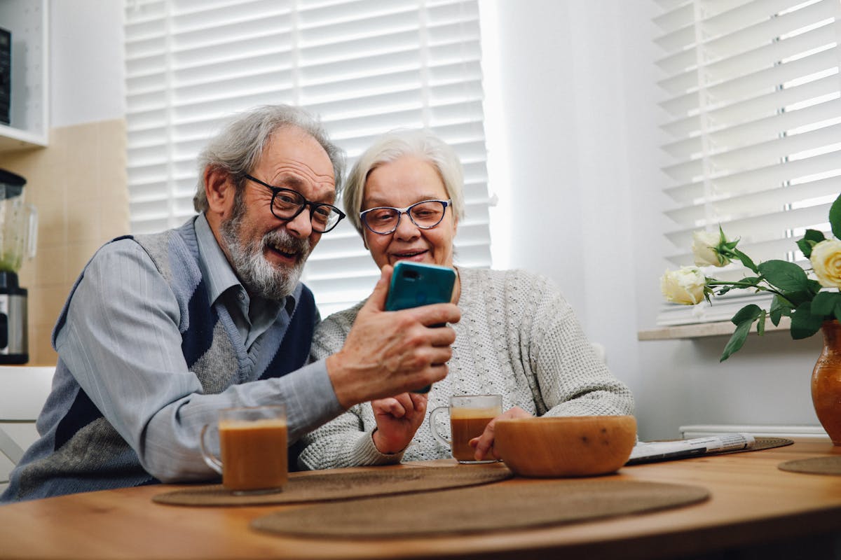 A senior couple using a smartphone together, staying connected with family