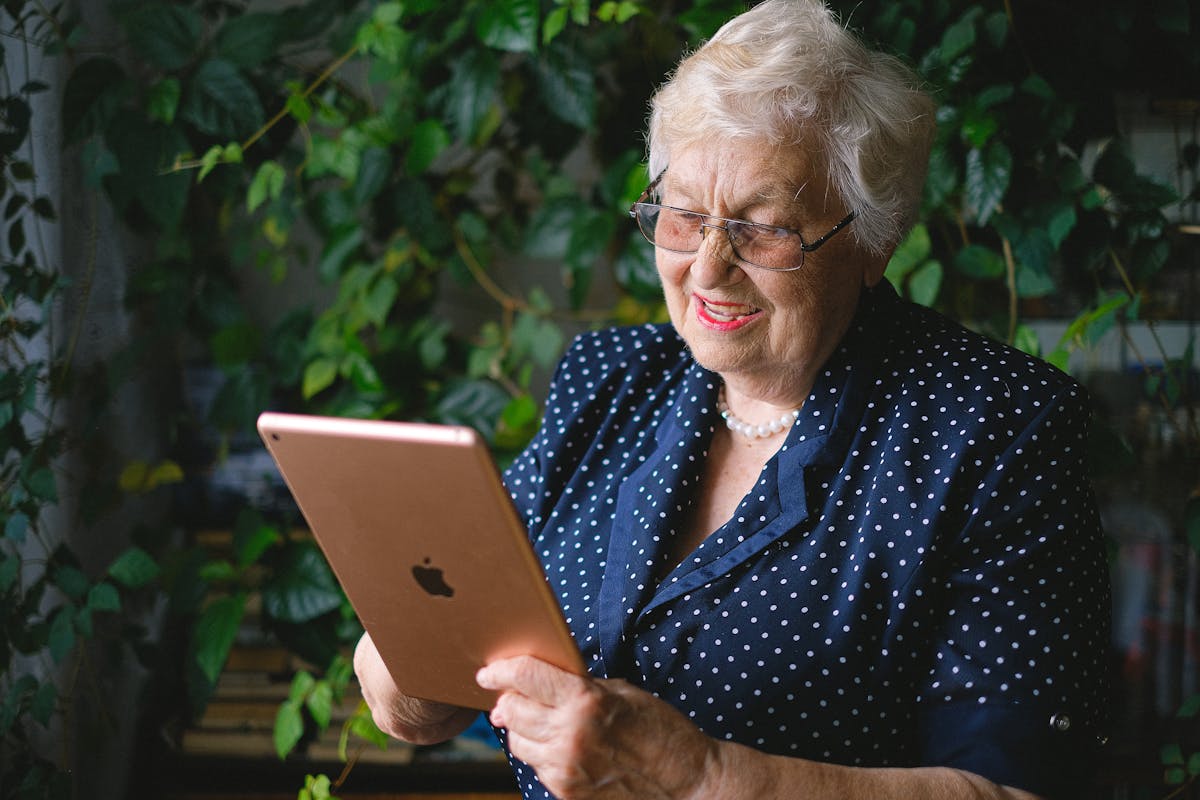 A senior woman smiling during a video call, staying connected with family and community from home